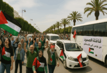 مشهد بانورامي لقافلة الصمود التونسية، تُظهر الحافلات والمشاركين المغاربيين يرفعون أعلام فلسطين، في طريقهم الرمزي نحو غزة تضامنًا مع الشعب الفلسطيني.