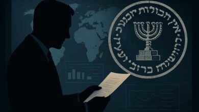 تُظهر الصورة الظلية لرجل يرتدي بدلة ورابطة عنق وهو يقرأ وثيقة أو أوراقًا، ويظهر وجهه في الظل. على خلفية زرقاء داكنة، يوجد شعار كبير دائري الشكل يضم الشمعدان اليهودي (المينوراه) محاطًا بكتابة باللغة العبرية. تظهر أيضًا خريطة عالمية باهتة على الخلفية، بالإضافة إلى رسوم بيانية ومخططات إحصائية، مما يوحي بتحليل البيانات أو المعلومات الاستخباراتية. الأجواء العامة للصورة توحي بالجدية والسرية.